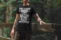 Man standing on a bridge at a national park wearing Black Short Sleeve Graphic Tee with printed quote : Right to bear Arms shall not be Infringed